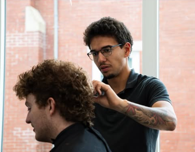 Barber Daniel DaSilva cutting a client's hair at Maverick Men's Grooming Center